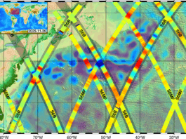 New Sea Satellite Data Released by NASA and European Partners A map showing a portion of the North Atlantic Ocean, with the U.S. Eastern seaboard along the left side of the frame, is covered with wide yellow lines criss-crossing in X shapes. Written on the lines in black ink is either “S6MF” for Sentinel-6 Michael Freilich or “S6B” for Sentinel-6B, showing the orbital paths of each satellite. On the left side of the image, a legend labeled “sea level anomaly (cm)” shows a vertical, rainbow-hued graph ranging from dark blue at the bottom to dark red at the top; the colors correspond to blobs of each shade that cover the ocean on the map.