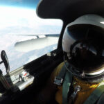 NASA’s Mineral Mapping Tech Takes Flight Over Western U.S. A high-angle, eye-level shot from inside the cockpit of an ER-2 aircraft shows a pilot in a full pressure suit and helmet, with the right wing of the plane and the Earth
