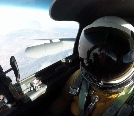 NASA’s Mineral Mapping Tech Takes Flight Over Western U.S. A high-angle, eye-level shot from inside the cockpit of an ER-2 aircraft shows a pilot in a full pressure suit and helmet, with the right wing of the plane and the Earth