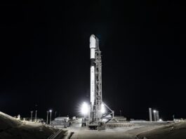 NASA, Europe Ready to Launch Sentinel-6B Earth Satellite A wide-angle, distant photo of a white rocket on the launch pad, brightly lit, with a black night sky behind it.