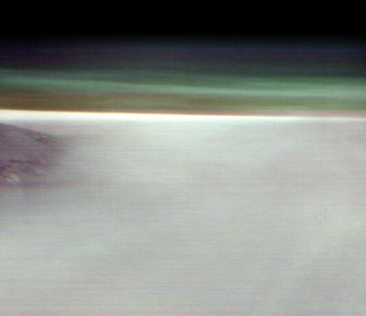 Mars Volcano Emerges Above Morning Clouds in NASA Image A softly focused, orbital view of the Arsia Mons volcano on Mars. The dark, rounded peak of the volcano emerges from a vast, bright white expanse of orographic clouds covering the planet