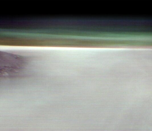 NASA Explores Fog-Covered Martian Volcano A black mountain peak shows through water ice clouds on Mars. Just above the clouds is the hazy green Martian atmosphere.