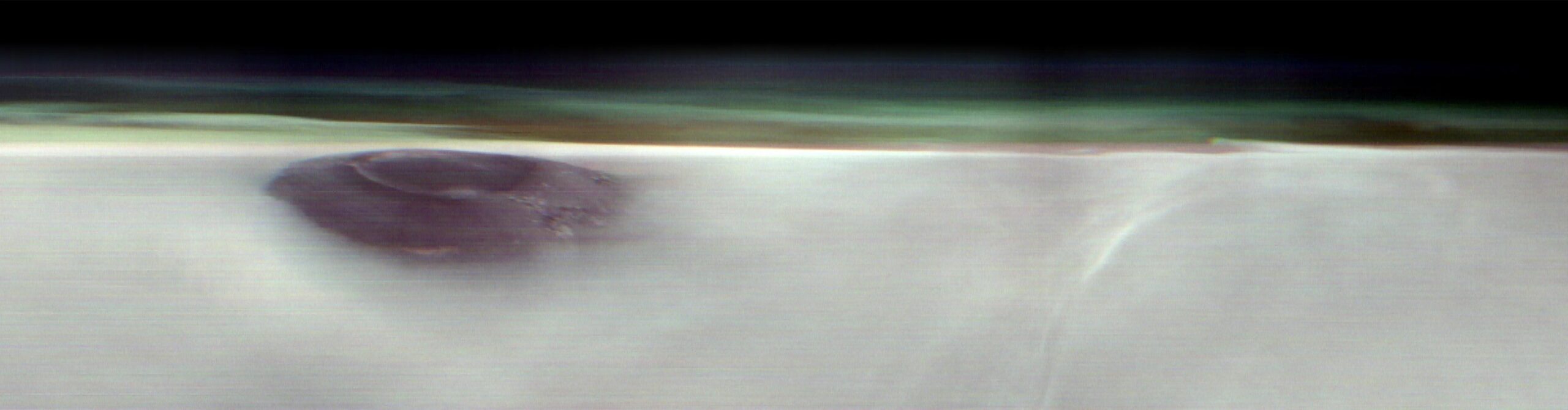 1 themis views mars arsia mons volcano crop1 c27fa8.webp.jpeg A black mountain peak shows through water ice clouds on Mars. Just above the clouds is the hazy green Martian atmosphere.