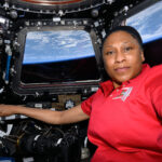 NASA Announces Retirement of Astronaut Jeanette Epps A black woman in a red shirt poses in the International Space Station cupola with the Earth pictured behind her.