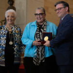 NASA Celebrates Unsung Heroes Two Black women and a white man face slightly left as they pose for a photo. The man and the woman in the middle hold a box containing a Congressional Gold Medal.