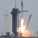 NASA’s Crew-11 Successfully Heads to International Space Station A rocket lifts off from the launchpad, leaving a trail of flames and plumes of vapor in its wake. A white structure and the black gantry can be seen on the left. On the right, a white arm falls away. The photo is taken from a distance.