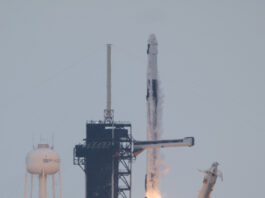 NASA’s Crew-11 Successfully Heads to International Space Station A rocket lifts off from the launchpad, leaving a trail of flames and plumes of vapor in its wake. A white structure and the black gantry can be seen on the left. On the right, a white arm falls away. The photo is taken from a distance.