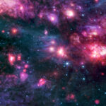 Sagittarius B2 Cloud Explored by NASA Cosmic clouds of pink and purple, some with bright centers, are surrounded by dark areas that appear like black space dotted with bright blue stars. A group of small clouds to the right is more red than any other area of the image.