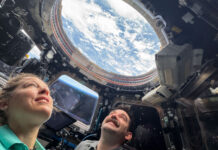 NASA Launches New Initiative to Explore the Night Sky Two astronauts look up through a round window in the International Space Station