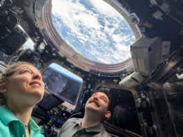 NASA Launches New Initiative to Explore the Night Sky Two astronauts look up through a round window in the International Space Station