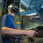 NASA Experiments with Mixed Reality in Vertical Motion Simulator A pilot, Damien Hischier, of the National Test Pilot School dons virtual reality goggles inside a Virtual Motion Simulator at NASA