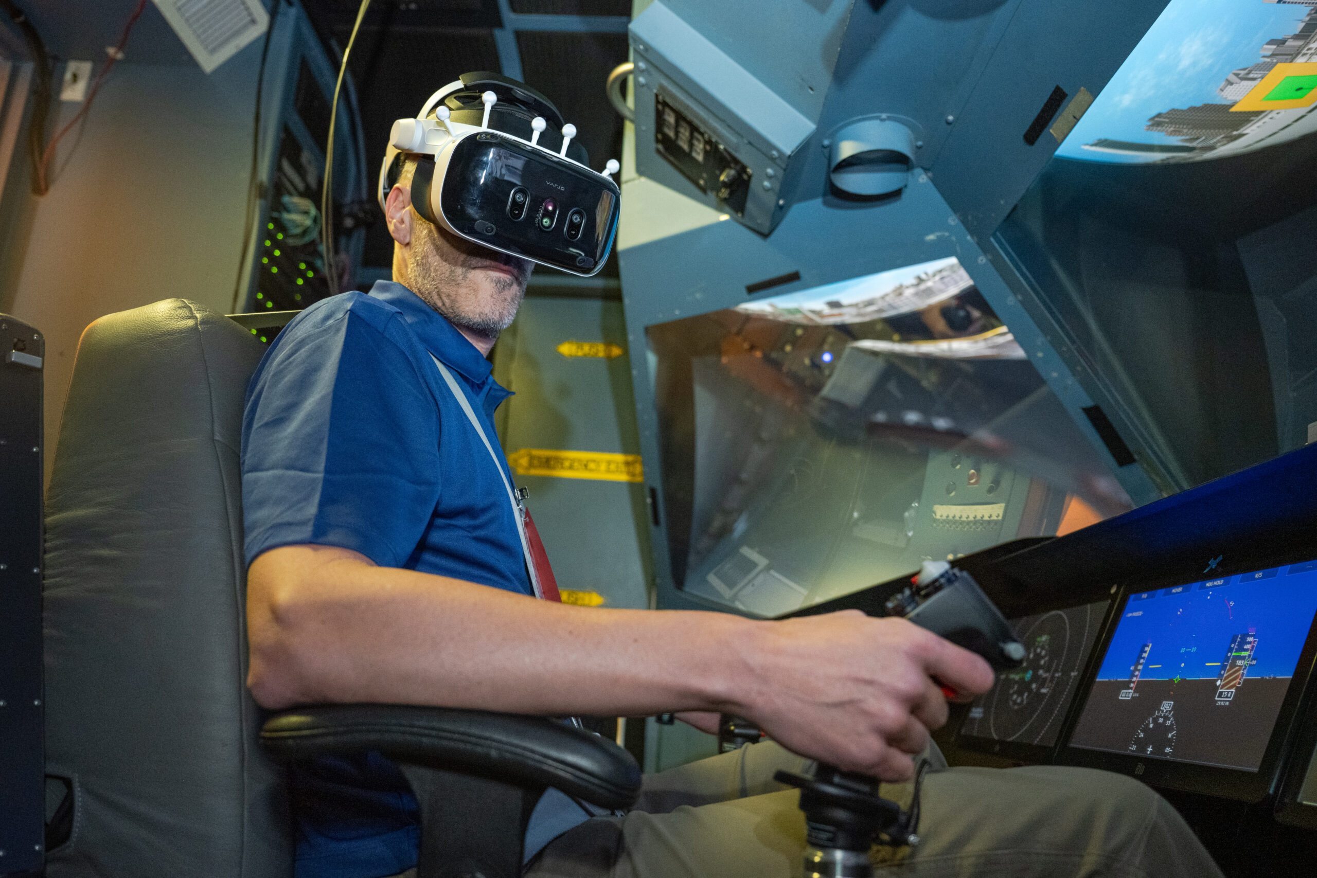 A pilot, Damien Hischier, of the National Test Pilot School dons virtual reality goggles inside a Virtual Motion Simulator at NASA