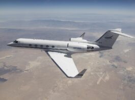 NASA G-IV Aircraft to Test Advanced Science Instrumentation A white Gulfstream IV airplane flies to the left of the frame over a tan desert landscape below and blue mountain ranges in the back of the image. The plane’s tail features the NASA logo, and its wings have winglets. Visible in the lower right third of the image, directly behind the airplane’s wingtip is the Mojave Air and Space Port in Mojave, California.