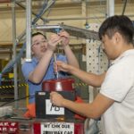 NASA Tests Innovative Wing Concept for Improved Efficiency Two men prepare a wing test article for obtaining vibration data.