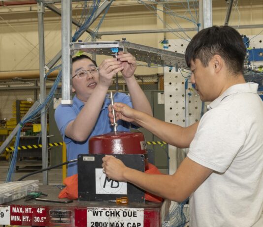 NASA Tests Innovative Wing Concept for Improved Efficiency Two men prepare a wing test article for obtaining vibration data.