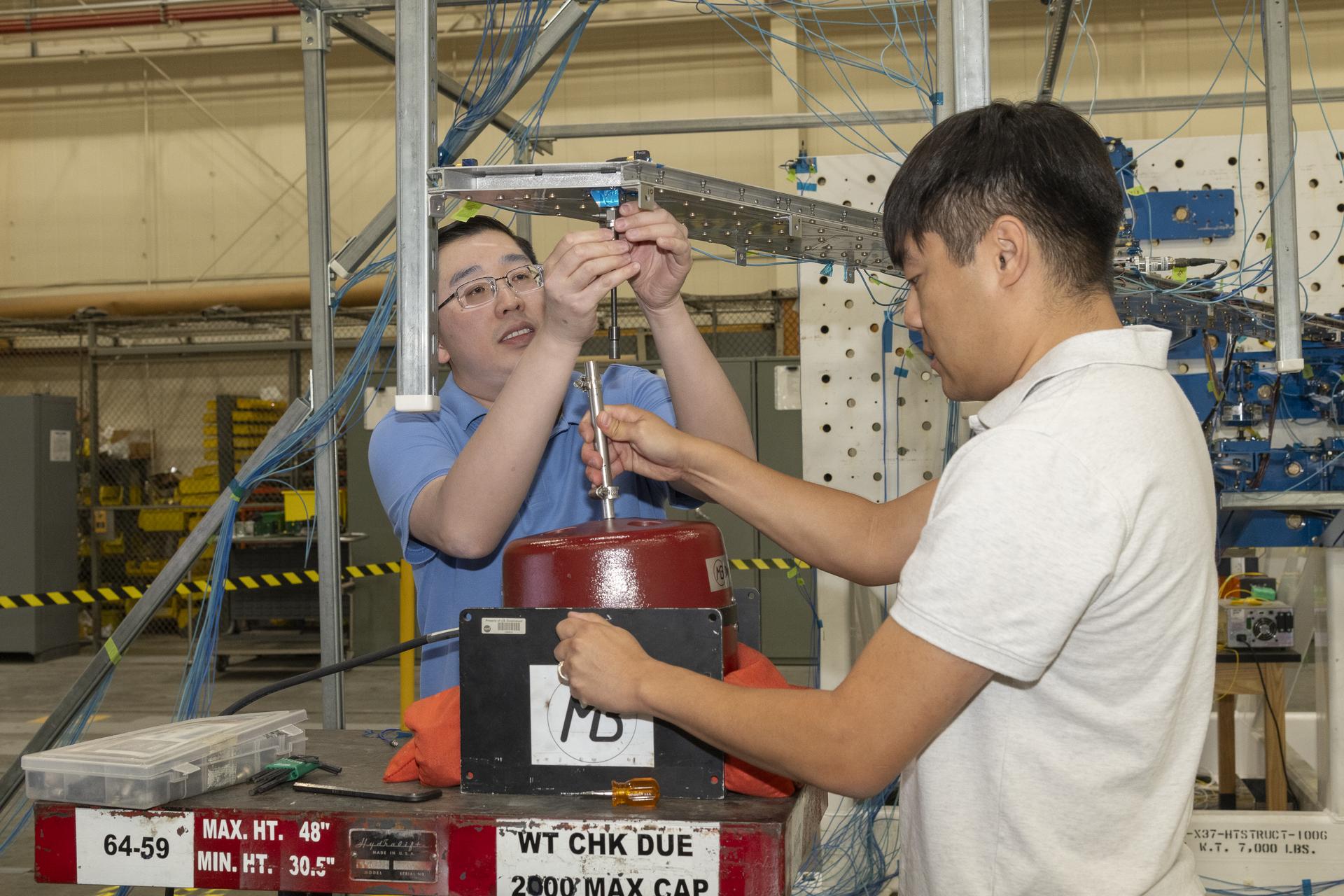 afrc2024 0142 096large.jpg Two men prepare a wing test article for obtaining vibration data.