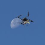 NASA Test Flight Success for Atmospheric Probe An atmospheric probe model carried by a quad rotor aircraft rises and the Moon is visible.