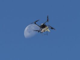 NASA Test Flight Success for Atmospheric Probe An atmospheric probe model carried by a quad rotor aircraft rises and the Moon is visible.