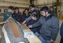 NASA Sparks Innovation in High School Engineering Club Students are examining a piece of equipment used for testing.