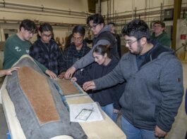 NASA Sparks Innovation in High School Engineering Club Students are examining a piece of equipment used for testing.