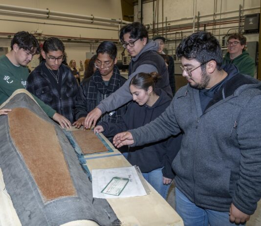 NASA Sparks Innovation in High School Engineering Club Students are examining a piece of equipment used for testing.