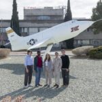 NASA Internships Propel Career Growth Students pose side-by-side in front of a static aircraft display in front of a building at NASA Armstrong. The students are wearing professional clothes and sneakers.