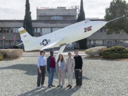 NASA Internships Propel Career Growth Students pose side-by-side in front of a static aircraft display in front of a building at NASA Armstrong. The students are wearing professional clothes and sneakers.