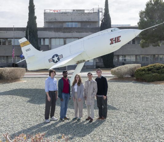 NASA Internships Propel Career Growth Students pose side-by-side in front of a static aircraft display in front of a building at NASA Armstrong. The students are wearing professional clothes and sneakers.
