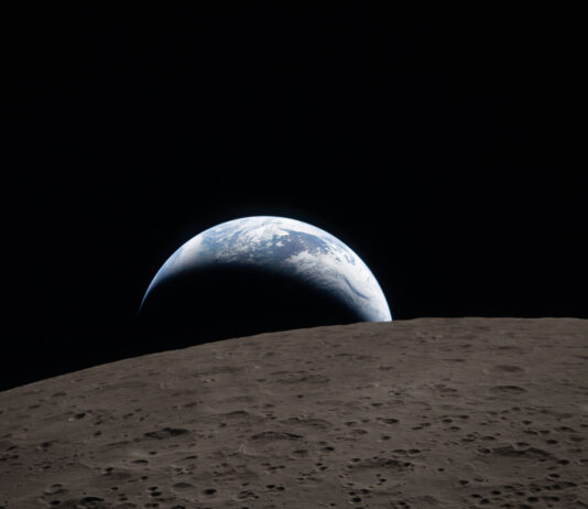 NASA Unveils Earthset: A New Tool for Global Environmental Monitoring A muted blue Earth with bright white clouds sets behind the cratered lunar surface. The dark portion of Earth is experiencing nighttime. On Earth’s day side, swirling clouds are visible over the Australia and Oceania region. In the foreground, Ohm crater has terraced edges and a flat floor interrupted by central peaks. Central peaks form in complex craters when the lunar surface, liquefied on impact, splashes upwards during the crater’s formation.