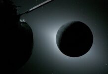 NASA’s Artemis II Crew Shares Official Moon Flyby Photos with Earth The Moon, backlit by the Sun during a solar eclipse, is photographed by NASA’s Orion spacecraft on April 6, 2026, during the Artemis II mission. Orion is visible in the foreground on the left. Earth is reflecting sunlight at the left edge of the Moon, which is slightly brighter than the rest of the disk. The bright spot visible just below the Moon’s bottom right edge is Saturn. Beyond that, the bright spot at the right edge of the image is Mars.