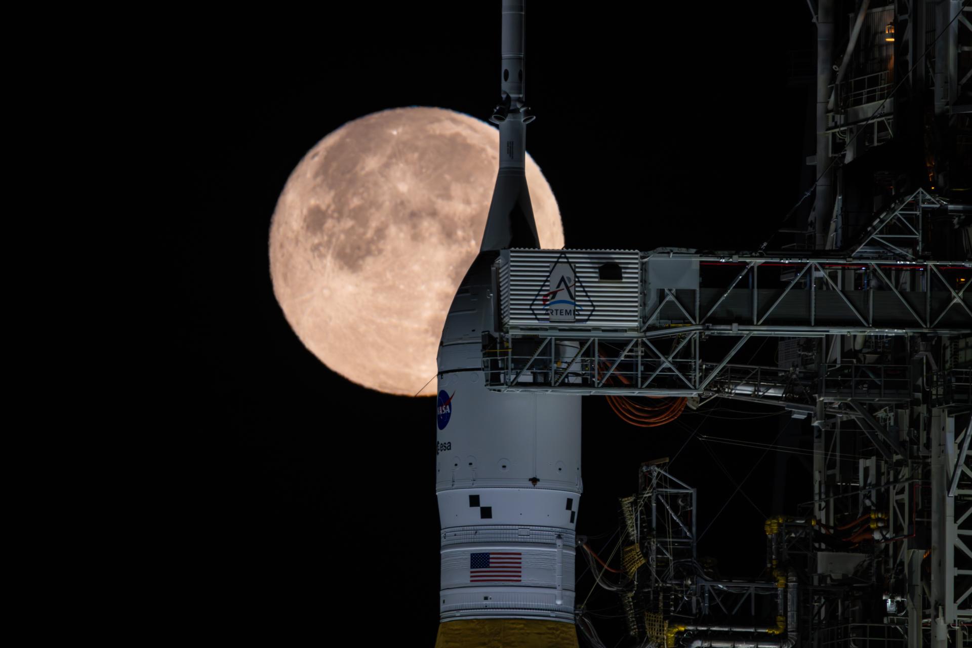 The Moon is seen shining over the SLS (Space Launch System) and Orion spacecraft, atop the mobile launcher on February 1, 2026. The rocket is currently at Launch Pad 39B at NASA’s Kennedy Space Center in Florida, as teams are preparing for a wet dress rehearsal to practice timelines and procedures for the launch of Artemis II.