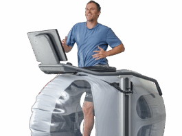 NASA Innovation Enhances Treadmill Experience A man runs on a high tech treadmill, a large bubble-like structure surrounds his lower body