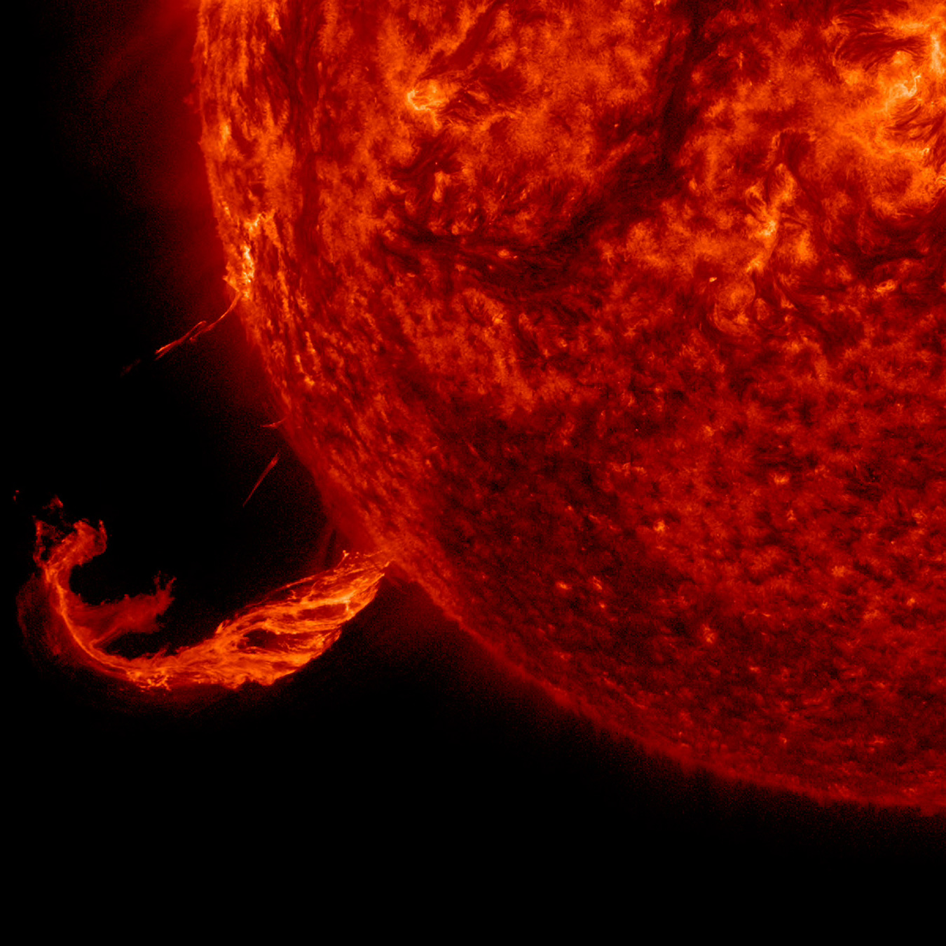 brief outburst 16760026566 oorig.jpg This image focuses on a twisting jet of material erupting from the Sun, glowing bright against the black backdrop of space. The Sun is a fiery, deep red ball taking up three-quarters of the image on the right.