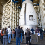 October 30, 2024: NASA Features in The Marshall Star A group of Marshall team members gather below the development test article for the universal stage adapter that will be used on the second variant of SLS, called Block 1B. The universal stage adapter is located inside one of the high bays in building 4619. The universal stage adapter will connect the Orion spacecraft to the SLS exploration upper stage. With the exploration upper stage, which will be powered by four RL10-C3 engines, SLS will be capable of lifting more than 105 metric tons (231,000 pounds) from Earth’s surface. This extra mass capability enables SLS to send multiple large payloads to the Moon on the same launch.