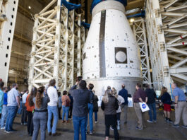 October 30, 2024: NASA Features in The Marshall Star A group of Marshall team members gather below the development test article for the universal stage adapter that will be used on the second variant of SLS, called Block 1B. The universal stage adapter is located inside one of the high bays in building 4619. The universal stage adapter will connect the Orion spacecraft to the SLS exploration upper stage. With the exploration upper stage, which will be powered by four RL10-C3 engines, SLS will be capable of lifting more than 105 metric tons (231,000 pounds) from Earth’s surface. This extra mass capability enables SLS to send multiple large payloads to the Moon on the same launch.