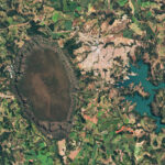 NASA Observes Central Brazil’s Cerrado Ecosystem A dark-green and brown oval-shaped plateau oriented north-to-south is prominent toward the left side of this satellite image of Brazil. A reservoir with branching arms takes up the right side of the image, and a light-colored developed area sits between the plateau and reservoir. A patchwork of irregularly shaped fields surrounds those features.