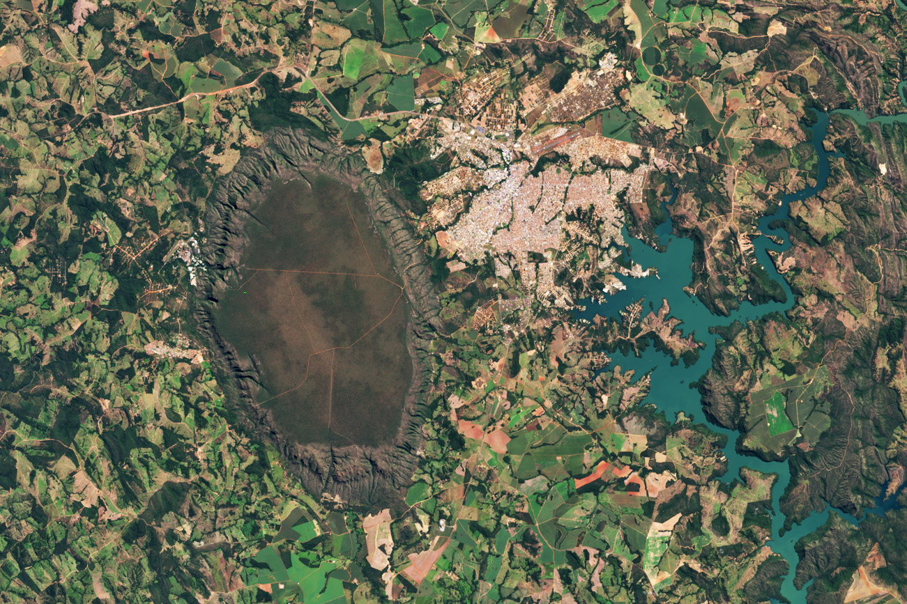 caldasridge oli2 20250519 lrg.jpg A dark-green and brown oval-shaped plateau oriented north-to-south is prominent toward the left side of this satellite image of Brazil. A reservoir with branching arms takes up the right side of the image, and a light-colored developed area sits between the plateau and reservoir. A patchwork of irregularly shaped fields surrounds those features.