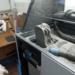 NASA Awards Propel University and Student Innovation from Campus 3D printing machine using a gray powder substance.