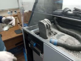 NASA Awards Propel University and Student Innovation from Campus 3D printing machine using a gray powder substance.