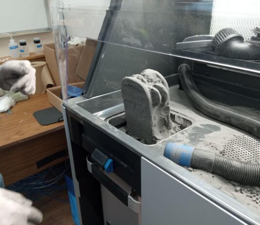 NASA Awards Propel University and Student Innovation from Campus 3D printing machine using a gray powder substance.