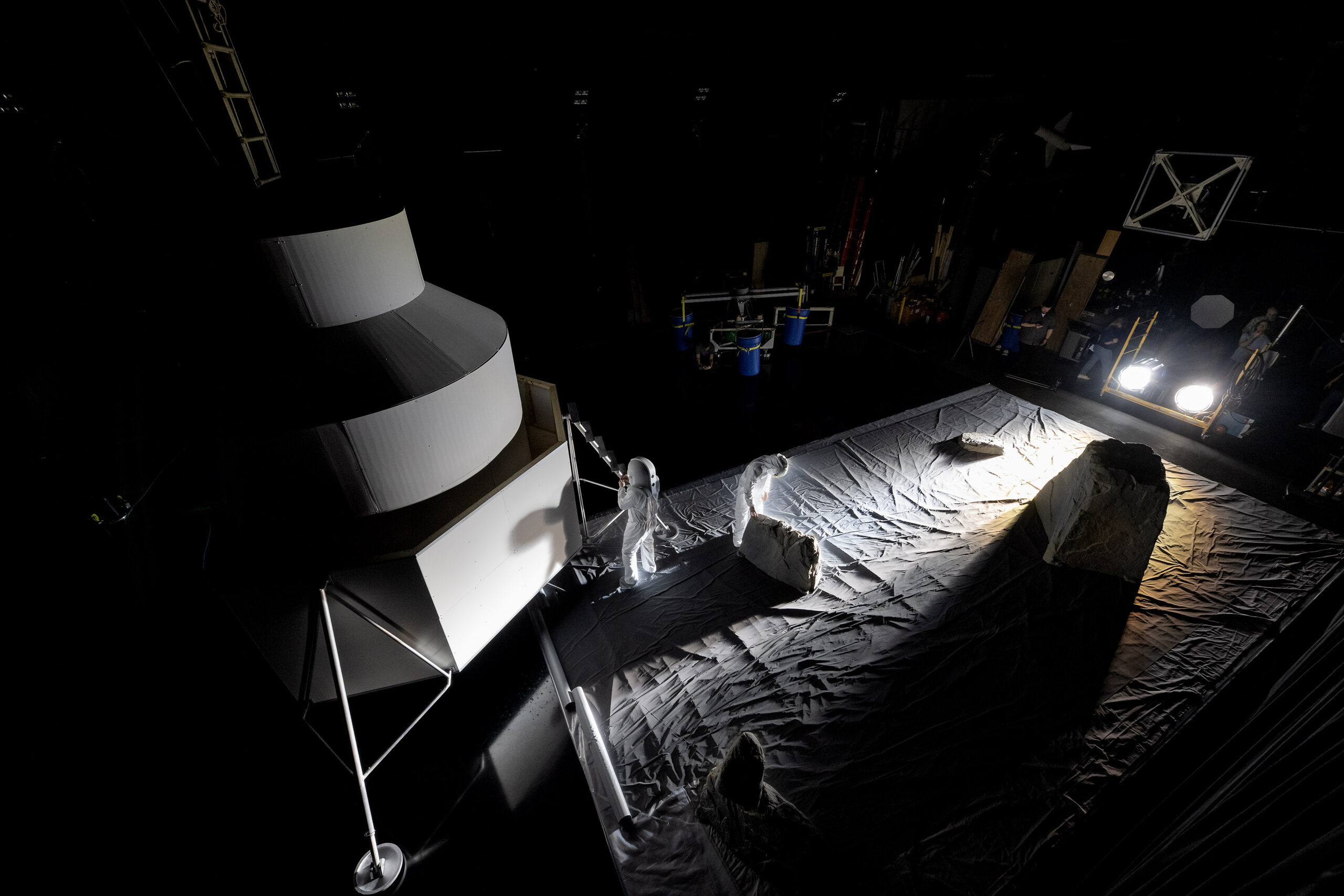 NASA engineers inside the Flat Floor Facility at Marshall Space Flight Center in Huntsville, Alabama, mimic lander inspection and assessment tasks future Artemis astronauts may do during Artemis III. Lights are positioned at a low angle to replicate the strong shadows that are cast across the lunar South Pole.