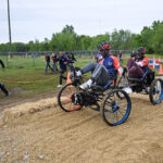 NASA Reveals Competitors for Global Rover Challenge Two students from Team Instituto Tecnologico de Santo Domingo from Santo Domingo, Dominican Republic, pedal their human-powered rover through the 2024 Human Exploration Rover Challenge course. Their teammates cheer them on from outside of the course.