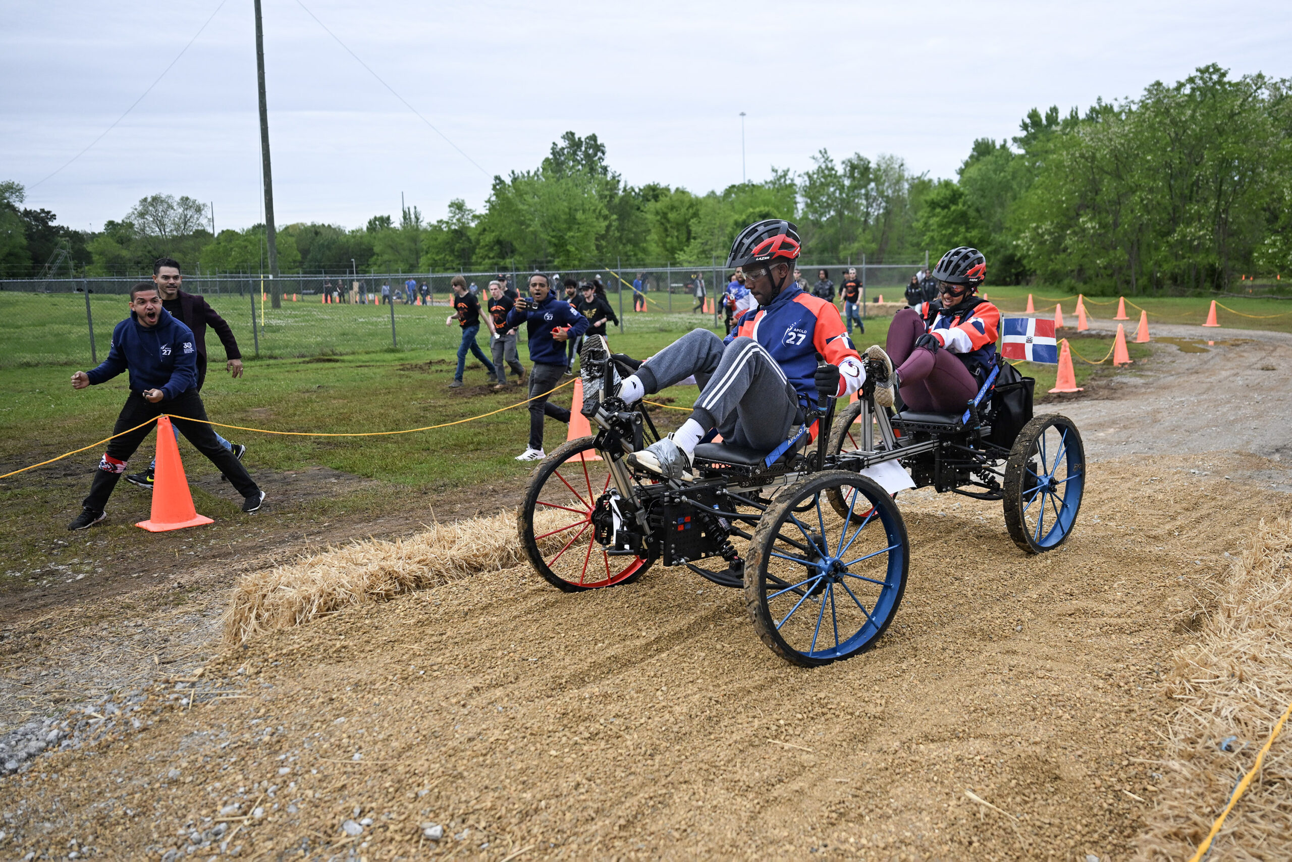 ceb 7389.jpg Two students from Team Instituto Tecnologico de Santo Domingo from Santo Domingo, Dominican Republic, pedal their human-powered rover through the 2024 Human Exploration Rover Challenge course. Their teammates cheer them on from outside of the course.
