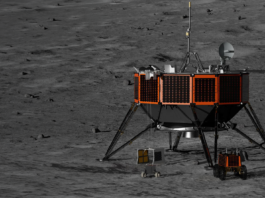 NASA chooses Intuitive Machines for Moon mission technology delivery. Rendering of the orange and black Nova-D lunar lander between two small lunar rovers on the dark gray surface of the Moon.