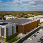 AI Factories’ Power Flexibility Stabilizing Global Energy Grids Image of Nebius AI factory in the UK surrounded by a parking lot and green foliage.
