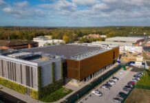 AI Factories’ Power Flexibility Stabilizing Global Energy Grids Image of Nebius AI factory in the UK surrounded by a parking lot and green foliage.