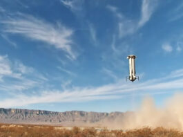 Successfully Navigate Difficult Terrain New Shepard booster landing in a field with blue sky in distance.