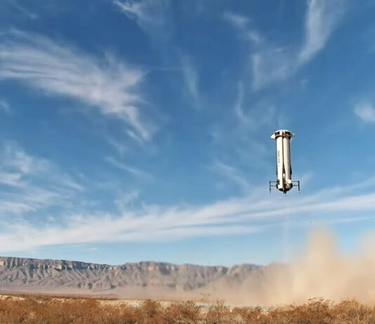 Successfully Navigate Difficult Terrain New Shepard booster landing in a field with blue sky in distance.