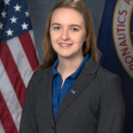 NASA Supports Research by Early Career Staff Portrait of Sylvie Crowell with an American flag and NASA flag partially shown behind her.