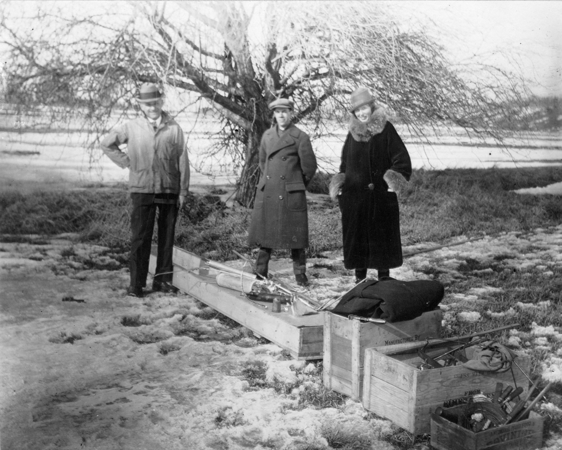 devliquidpropellantrocket fig128lg.jpg black-and-white photograph of a trio of people standing outdoors with wooden crates at their feet